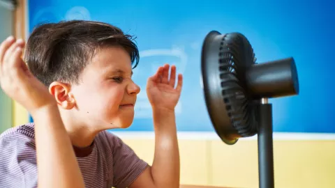 niño ante un ventilador