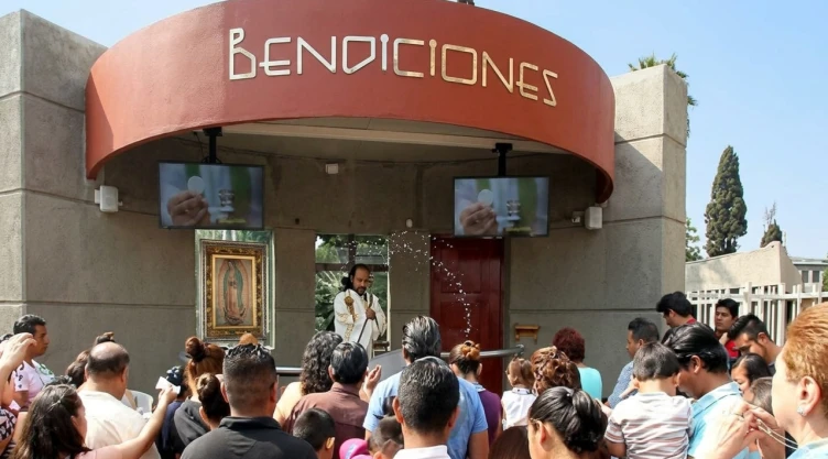 Fieles sosteniendo cuadros, figuras y objetos religiosos en la zona de bendiciones de la Basílica de Guadalupe.
