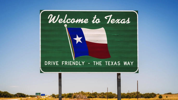 Cartel verde de bienvenida en la carretera con la bandera del Estado de Texas