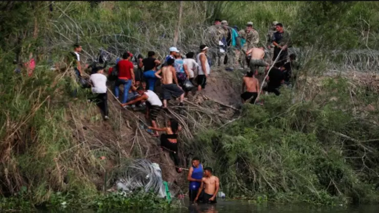 Tragedia Migrante: Localizan cuerpo entre el Río Bravo y alambre de púas, cerca de Ciudad Juárez. En la imagen se observa cómo un conjunto de migrantes trata de burlar la seguridad y saltar un alambre de puas en la frontera entre Ciudad Juárez y El Paso, Texas.