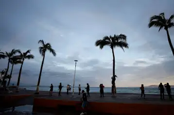 Personas frente a una playa en Puerto Vallarta tras el paso del huracán Simón.