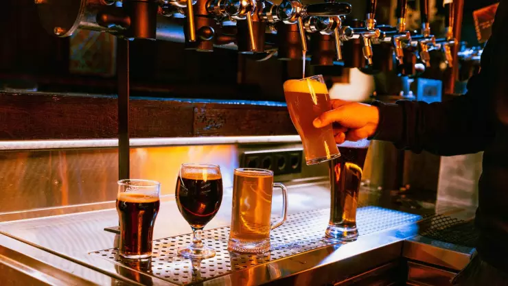 Un hombre sirve sabrosas cervezas en un bar 