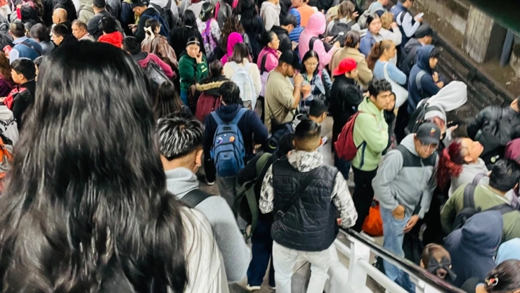 Foto de andén de la línea 8 del Metro CDMX lleno de personas.