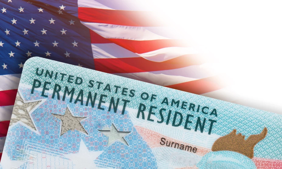 Una Green Card sobre una bandera estadounidense