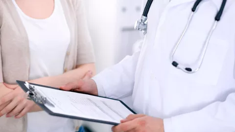 Un doctor le pregunta datos a una paciente.