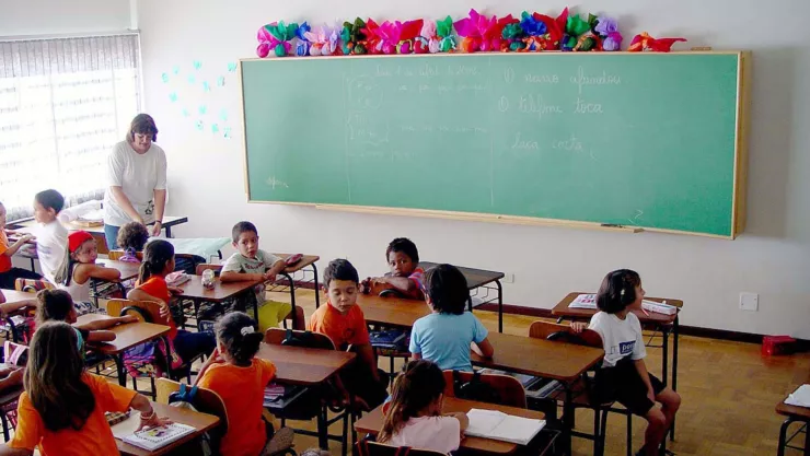 Un grupo de niños tomando clases en una escuela de educación básica