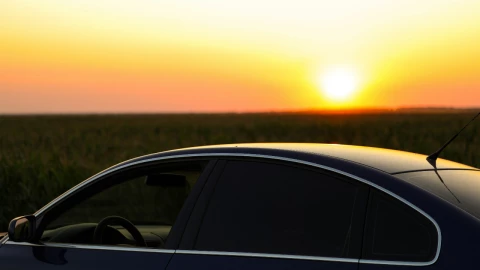 Imagen de un costado de un auto bajo el rayo del sol.