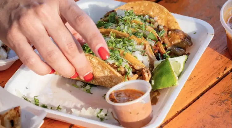 una mujer a punto de saborear unos deliciosos tacos