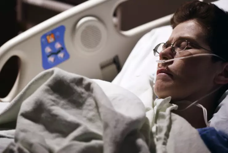 Un adolescente enfermo acostado en una camilla de un hospital