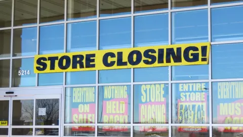 Una tienda pone un letrero que dice “tienda cerrando” y anuncia descuentos.