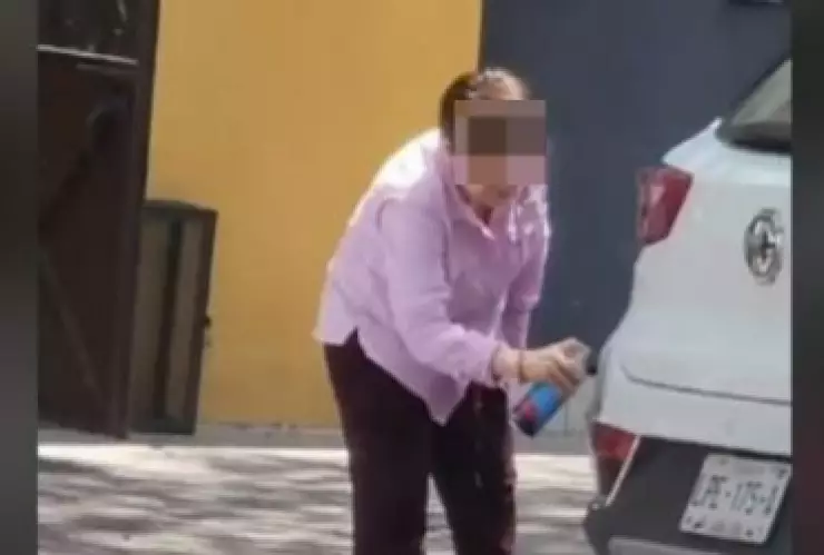 Señora raya camioneta con aerosol