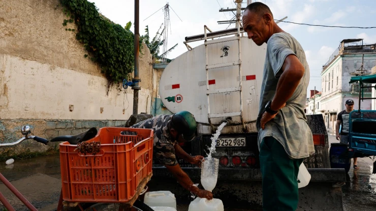 Un hombre llena un recipiente de plástico con agua potable de un camión cisterna mientras la economía estatal cubana se hunde en una profunda crisis después de que la administración del presidente estadounidense Donald Trump endureciera las sanciones y cortara el suministro de petróleo a la nación caribeña, en La Habana, Cuba , el 6 de mayo de 2026.