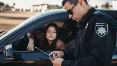 Un agente de tránsito pide la documentación a una joven.