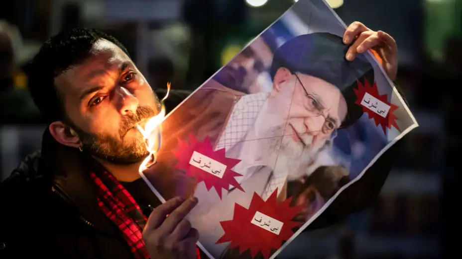 Un manifestante quema una foto del ayatolá Ali Jamenei, en Irán