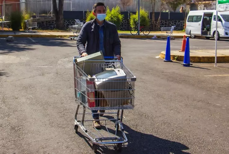 persona con un carrito de súper, llevando residuos eléctricos y électrónicos