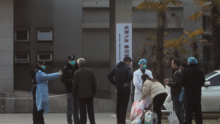 Medical staff and security personnel stop patients’ family members from being too close to the Jinyintan hospital, where the patients with pneumonia caused by the new strain of coronavirus are being treated, in Wuhan