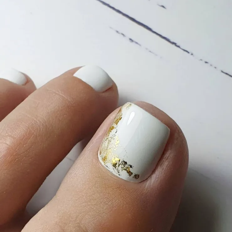 9 diseños de uñas blancas con dorado que puedes usar en los pies para lucir en natación