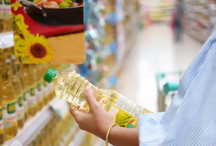 Mujer en supermercado comprando aceite