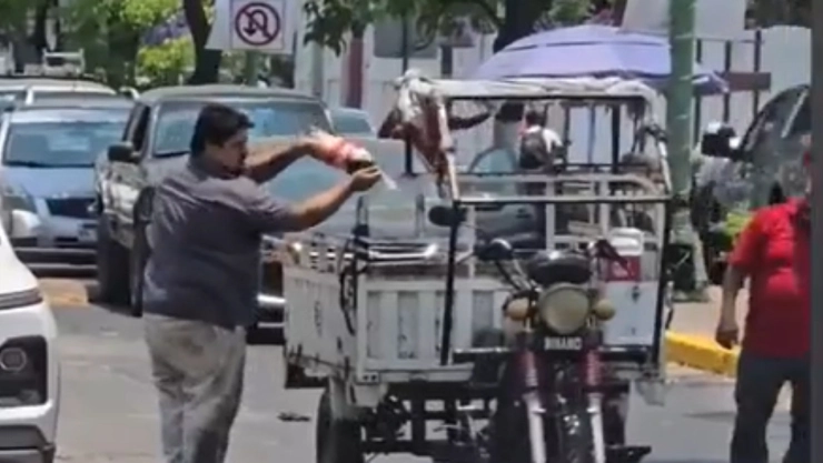 El hombre usa el refresco como si fuera un extintor para apagar el incendio de una moto.