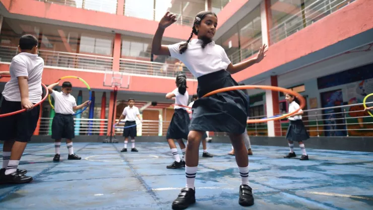 niños jugando con aros en el patio de la escuela