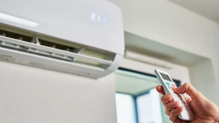 persona con el control del aire acondicionado