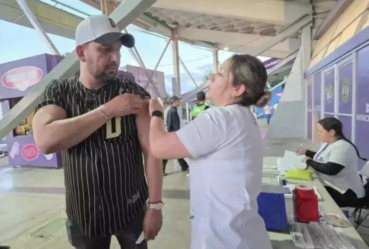 hombre_enfermera_aplicando_vacuna_sarampion_Chihuahua_enfermera_sentada