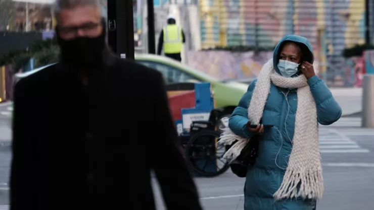 personas caminando por la ciudad con chamarras abrigadoras