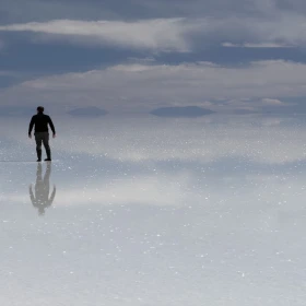 Turistas mexicanos caminan sobre el efecto espejo del Salar de Uyuni, Bolivia