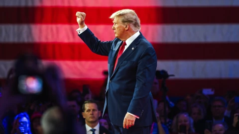 Donald Trump con una bandera de Estados Unidos de fondo