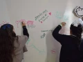 Alumnos de Jules Verné School dejando sus mensajes en el muro de la Villa Juguetón 25
