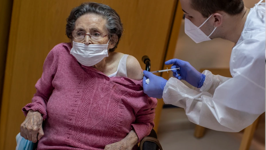 Adulta mayor recibe vacuna de Pfizer en España.