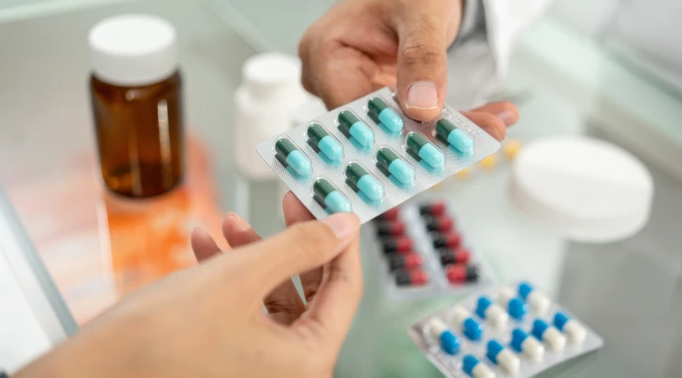 Dos manos agarran un blister de pastillas