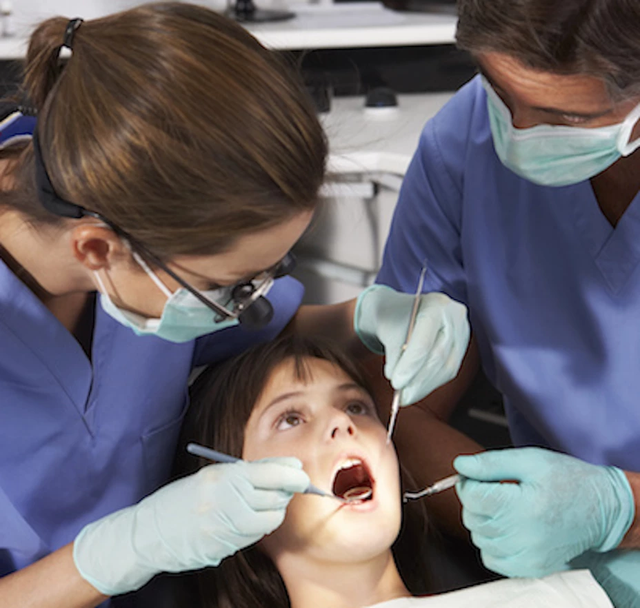 Dentist And Nurse Giving Girl Check Up