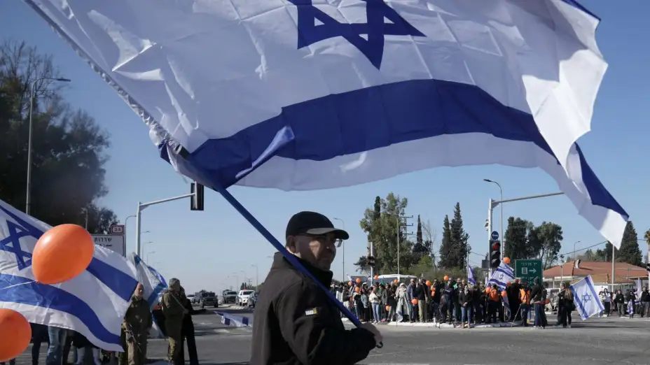 Israelíes esperan el paso de una comitiva fúnebre de rehenes entregados por Hamás.