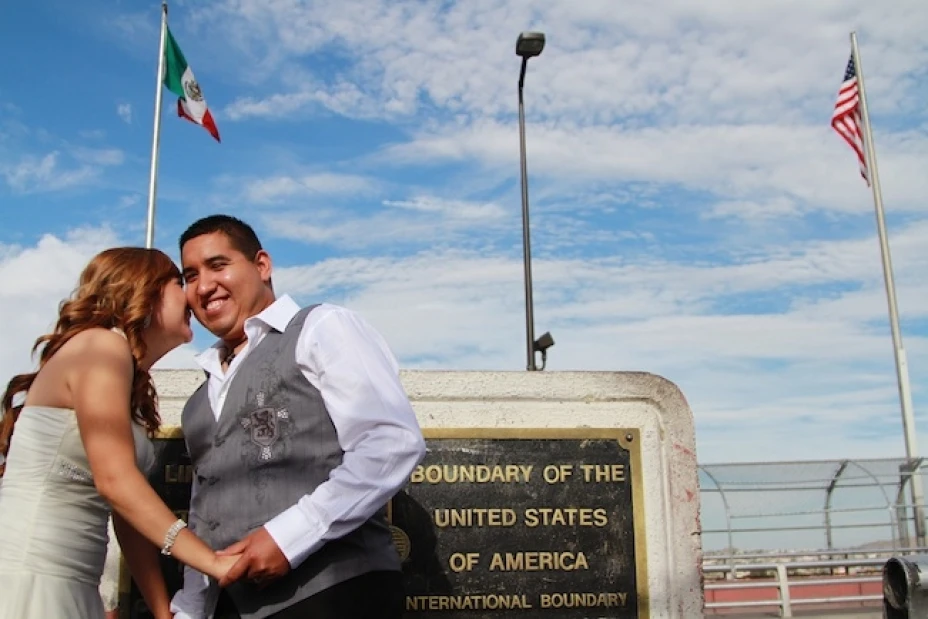 La mexicana Maricruz Valtierra, izquierda, y el estadounidense Edgar Falcón, derecha, ríen en la frontera entre México y Estados Unidos, donde se casaron