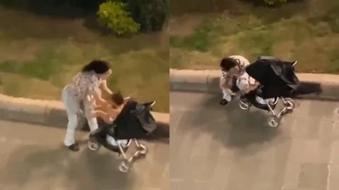 Aparece una mujer sentada en una jardinera, al lado hay una carriola negra con una bebé adentro. En la otra, la mujer avienta a la niña en la carriola negra.