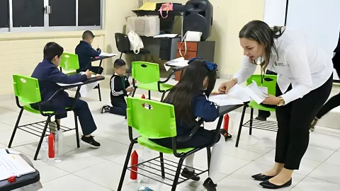Maestra y alumnos en salón de clases