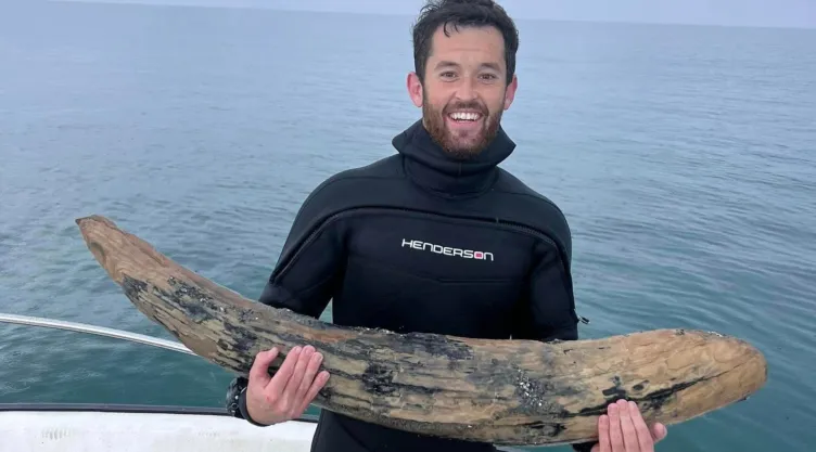 Alex Lundberg posa con el colmillo de mastodonte que encontró en Florida.