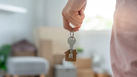 una mujer abre la puerta de su nueva casa.
