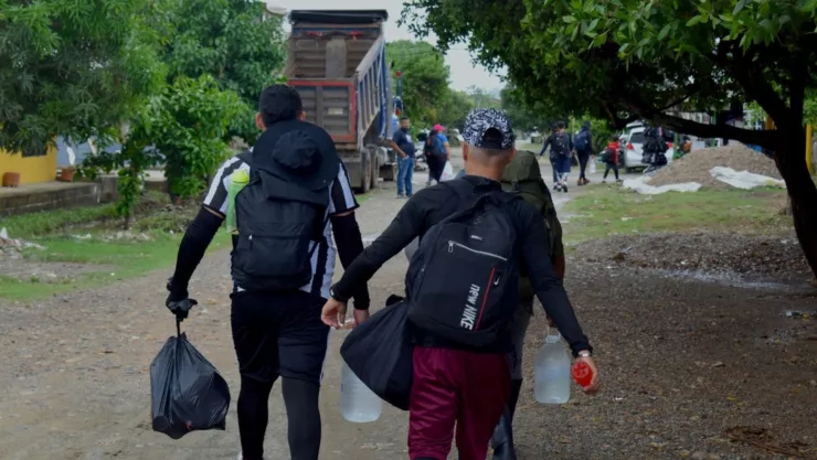 Dos migrantes caminan por la localidad de Necoclí, en Colombia, antes de cruzar el Darién.