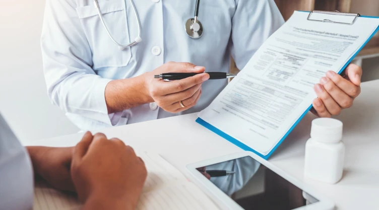 Una persona muestra la planilla de seguro médico a un paciente