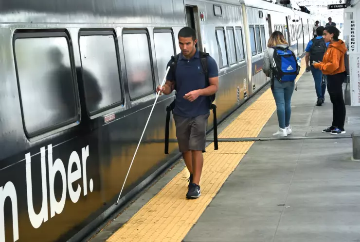 A blind man catches a train in Denver, Colorado