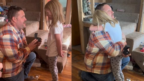 Hombre se arrodilla ante niña.