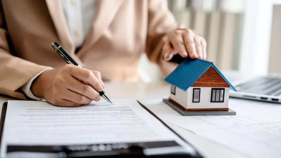 Una persona firma la hipoteca de una casa.