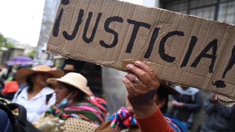 Multitud de personas en una calle de Bolivia con pancartas y banderas, expresando su descontento con la situación del país.