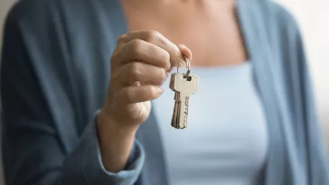 Una mujer sostiene en sus manos las llaves de una vivienda de alquiler.