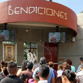 Fieles sosteniendo cuadros, figuras y objetos religiosos en la zona de bendiciones de la Basílica de Guadalupe.