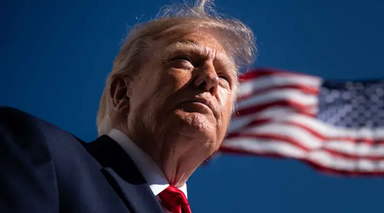 Donald Trump frente a la bandera de EU.