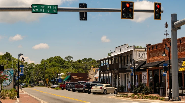 Calle de entrada a un pueblo de Florida, con su señalización, semáforo y locales a la vista