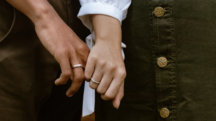Dos personas con anillos de casamiento